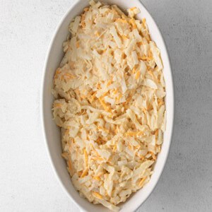 Shredded cabbage in a white dish on a white background.
