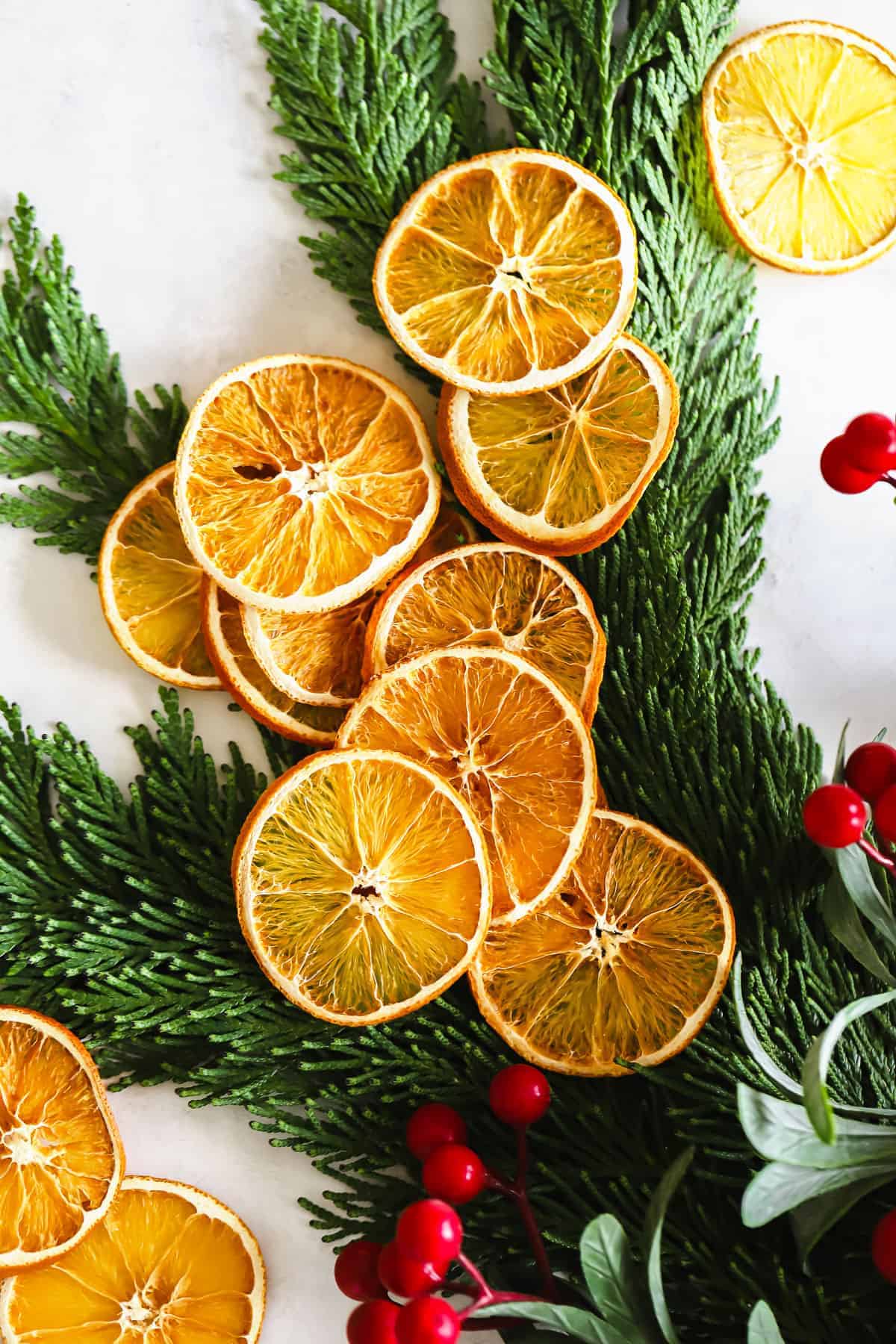 Dried orange garland is the perfect DIY holiday decor idea to add color and holiday cheer to any room in your home. dried oranges on green garland