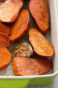 Roasted sweet potatoes in a green baking dish.