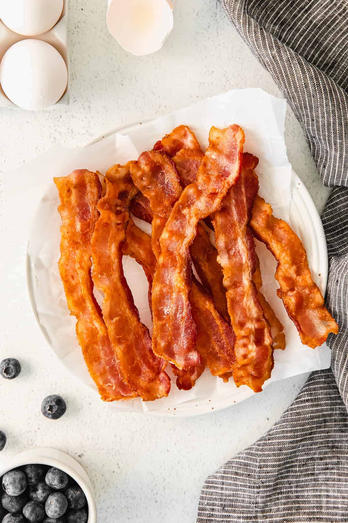 Learn how to cook bacon on the stove for a quick, no-fail way to make bacon! Your morning bacon will come out perfectly every time. bacon on plate