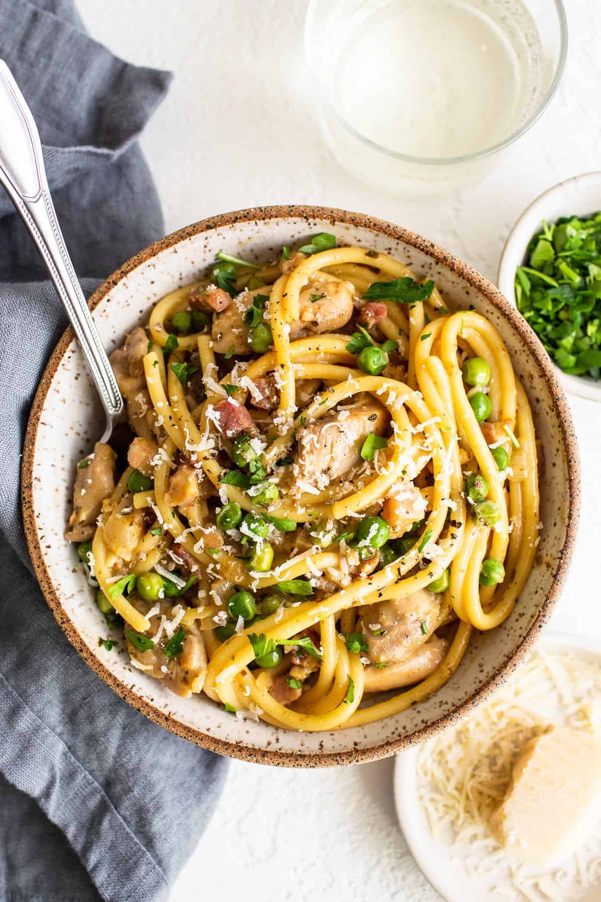 Homemade Chicken Carbonara is so much easier to make than you may think. In this post, we’ll teach you how to make chicken carbonara in less than 45 minutes! Chicken carbonara in a bowl with a spoon.