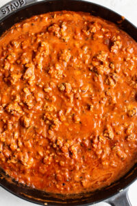 A skillet filled with meat and sauce.