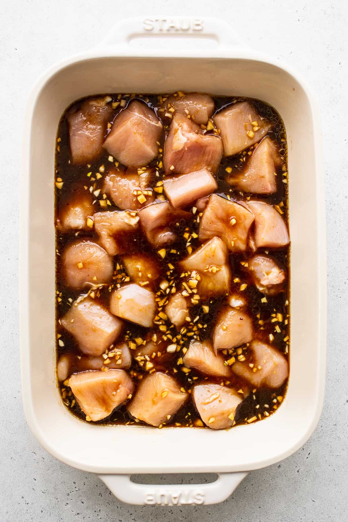 You'll never use another chicken kabob marinade! This one will leave your chicken and veggies so tender and juicy. chicken marinading in dish.