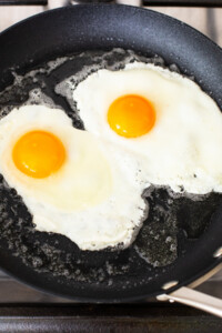 Two eggs are being fried in a frying pan.
