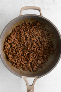 A frying pan filled with ground beef.