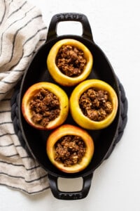 Stuffed apples in a cast iron skillet.