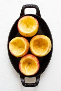 Sliced apples in a skillet on a white background.