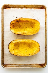 sliced spaghetti squash on baking sheet.