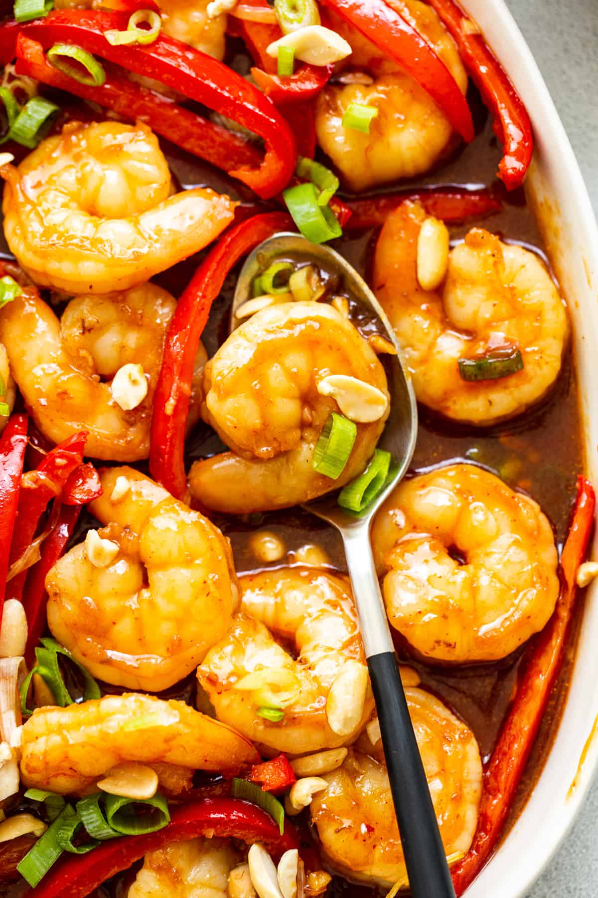 Kung pao shrimp is made with a sweet and spicy sauce, juicy shrimp, and bell peppers for a colorful, high-protein meal ready in 30 minutes. kung pao shrimp in serving dish.