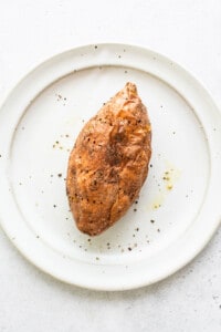 A cooked sweet potato on a plate.