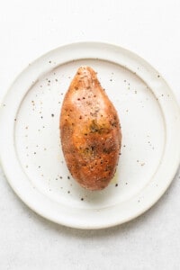 A sweet potato with holes on a plate.