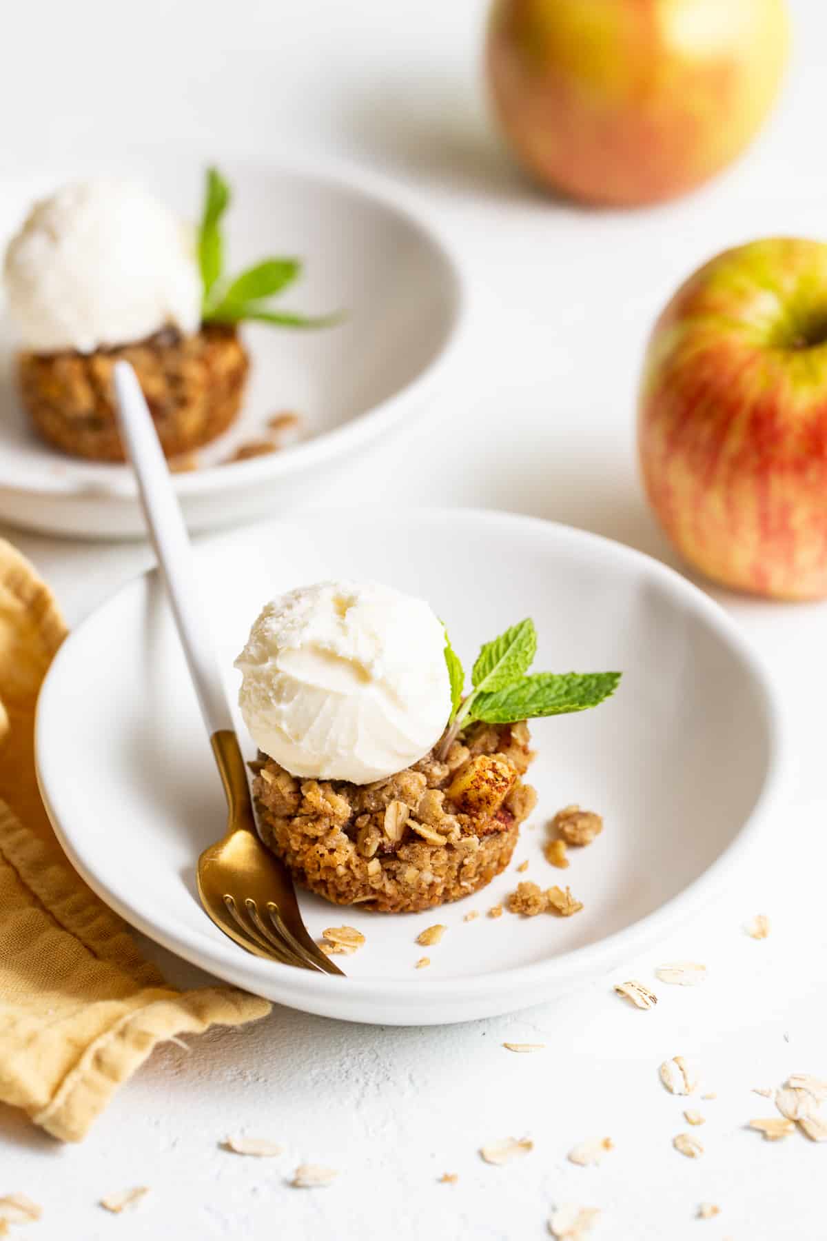 Mini apple crisps are a fun way to serve traditional apple crisps but in a single serving. Top them with vanilla ice cream for the perfect fall dessert. mini apple crisp in bowl.