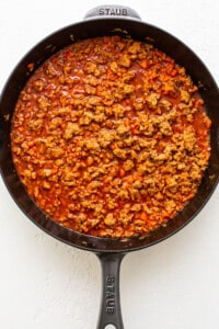 A skillet filled with meat and sauce.