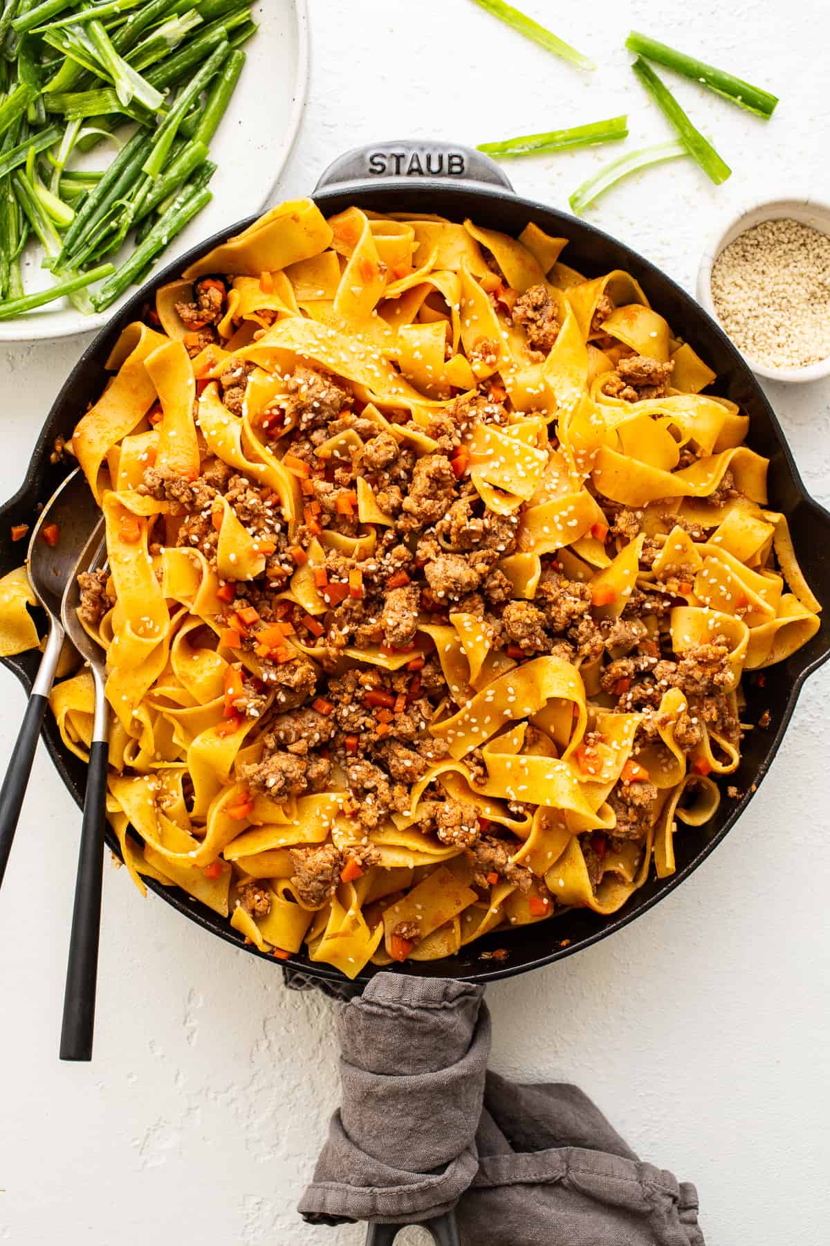These gochujang pork noodles are spicy, filling, and so delicious topped with a quick green onion salad and sesame seeds.