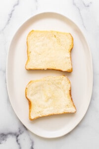 Two slices of bread on a white plate.
