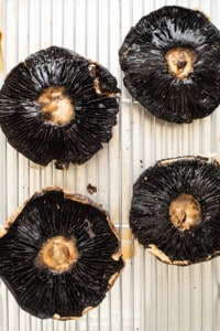 Portobello mushrooms on a baking sheet.