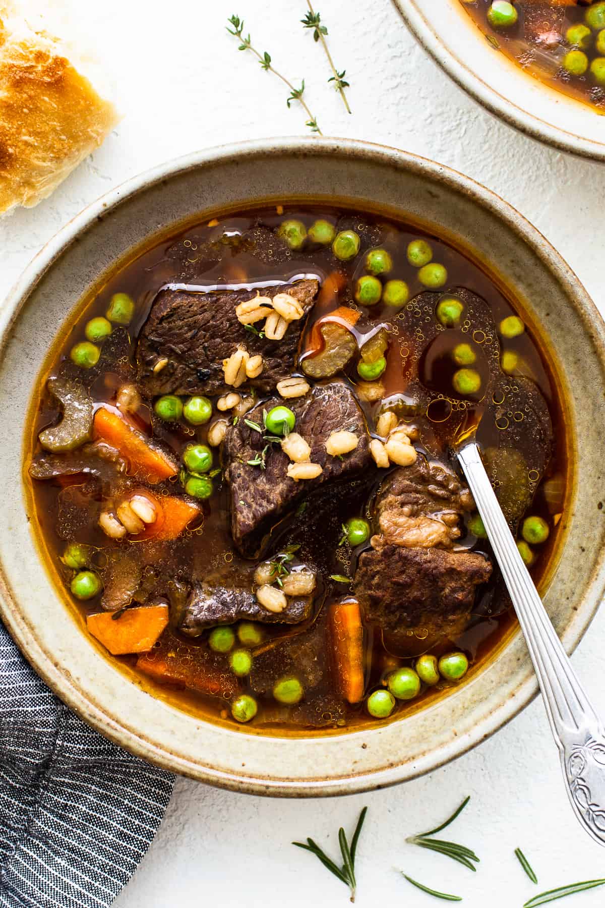 Warm this soul with this tender beef barley soup recipe. It's made with beef chuck roast, carrots, peas, barley, and delicious beef broth. bowl of beef and barley soup.
