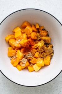 A bowl filled with chopped squash and spices.