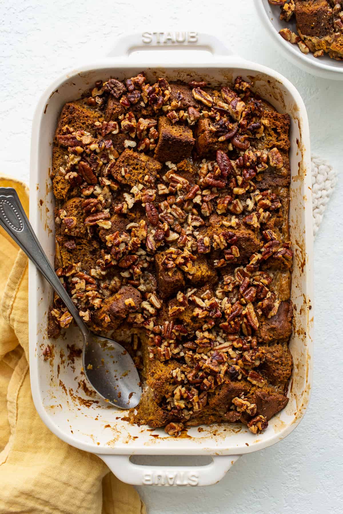 This pumpkin bread pudding recipe comes out tender and sweet and is made with an entire loaf of pumpkin bread for the ultimate fall dessert. pumpkin bread pudding in casserole dish.