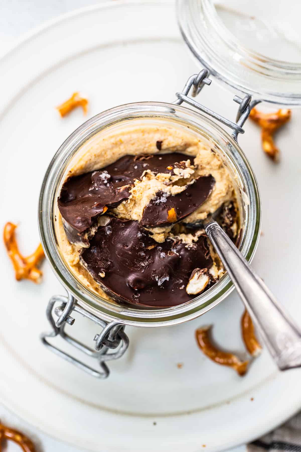 This easy pumpkin mousse comes complete with a decadent chocolate pretzel crack topping. Enjoy immediately or prep for an easy dessert later! Pumpkin mousse in a jar topped with chocolate topping.