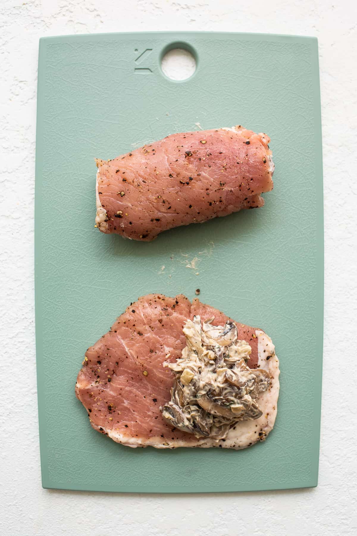 stuffing pork chops on cutting board.