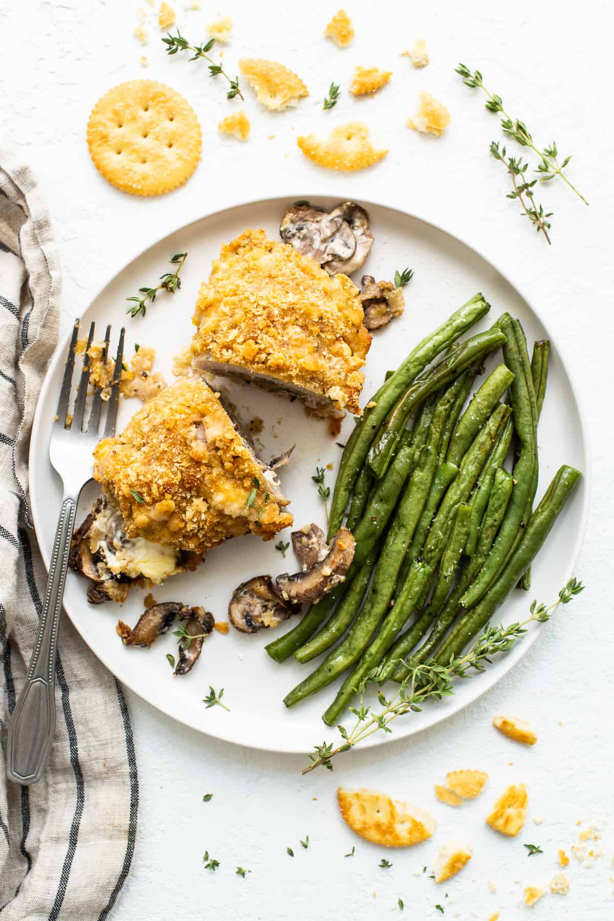 stuffed pork chop on plate with green beans.
