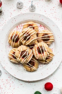 A plate of cookies with icing and sprinkles on it.