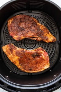 Two pieces of meat in an air fryer.