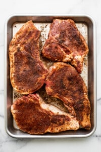 Roasted pork chops on a baking sheet.