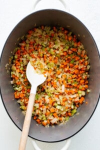 A pot with carrots and onions in it.
