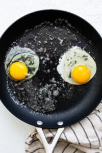 Two fried eggs in a frying pan.