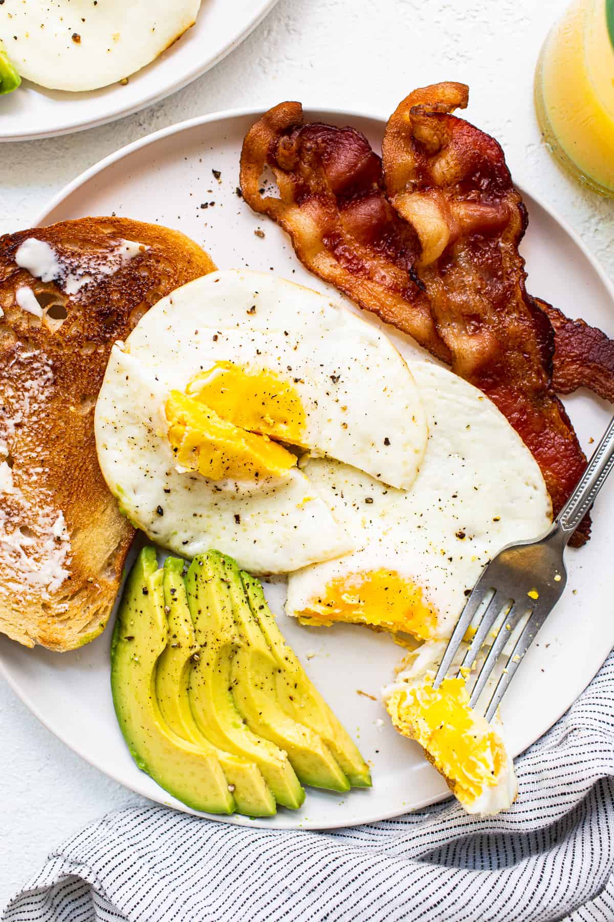 Make perfect eggs every time with this over hard eggs recipe. Step-by-step, easy fool proof instructions to make the best over hard eggs ever. Over hard eggs on a plate.