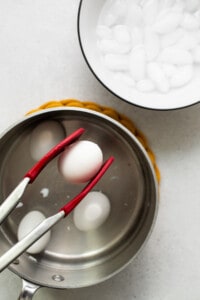 An egg in a pan with two forks.