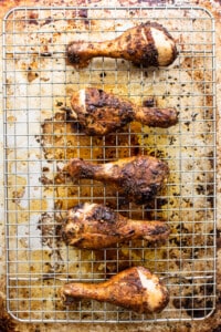 Roasted chicken legs on a cooling rack.