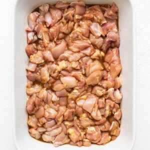 chicken marinating in casserole dish.