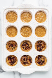 Peanut butter and jelly cups in a muffin tin.
