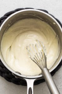 Whipping cream in a pan while preparing turkey wild rice soup.