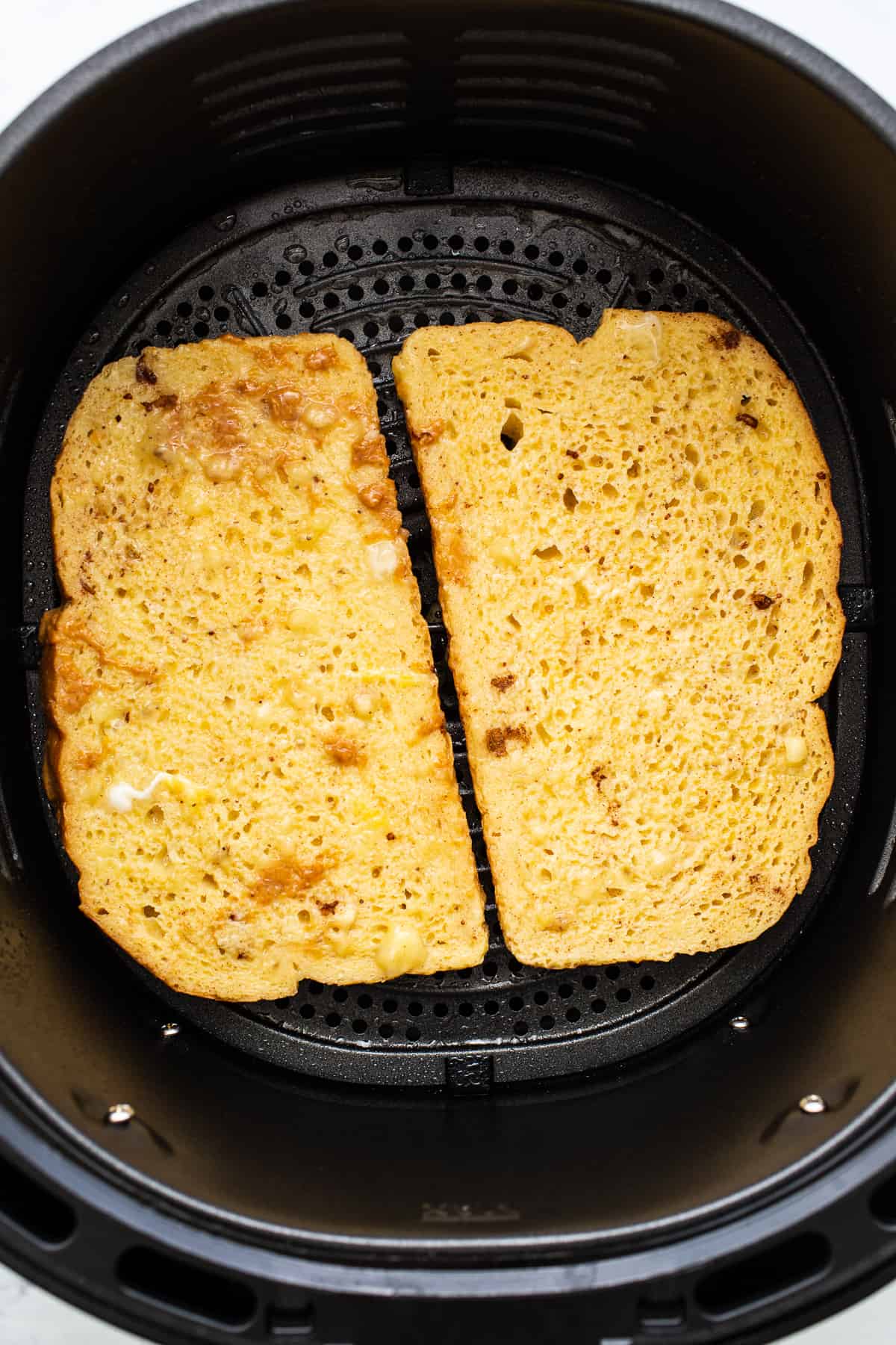 This air fryer chunky monkey French toast is a sweet breakfast eater's dream! The bread gets soaked in an egg mixture of banana, maple syrup, cinnamon, and peanut butter for an ultra-rich French toast topped with chocolate, roasted walnuts, and sliced bananas. French toast in an air fryer.