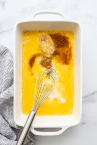 A white dish with a whisk in it.