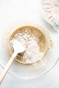 adding dry ingredients to wet in bowl.