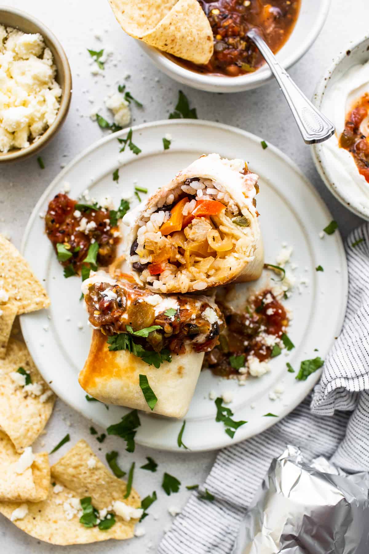 These chicken fajita burritos are filled with salsa chicken, fajita veggies, black beans, and rice. Yum! Chicken fajita burrito on a plate.