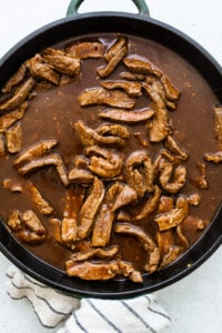 cooking beef in sauce in pan.