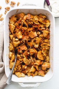 A white baking dish filled with bread and carrots.