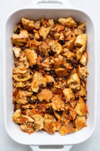 A white baking dish filled with bread and carrots.