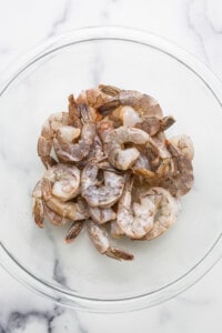 Shrimp in a glass bowl on a marble table.