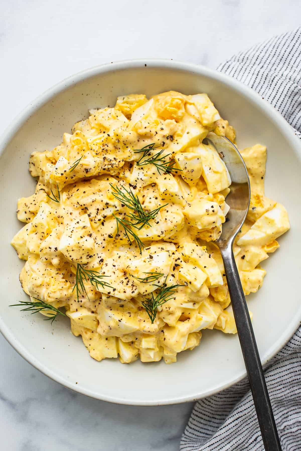 Learn how to make egg salad with this super simple egg salad recipe made with hard boiled eggs and a yummy sauce. bowl of egg salad.
