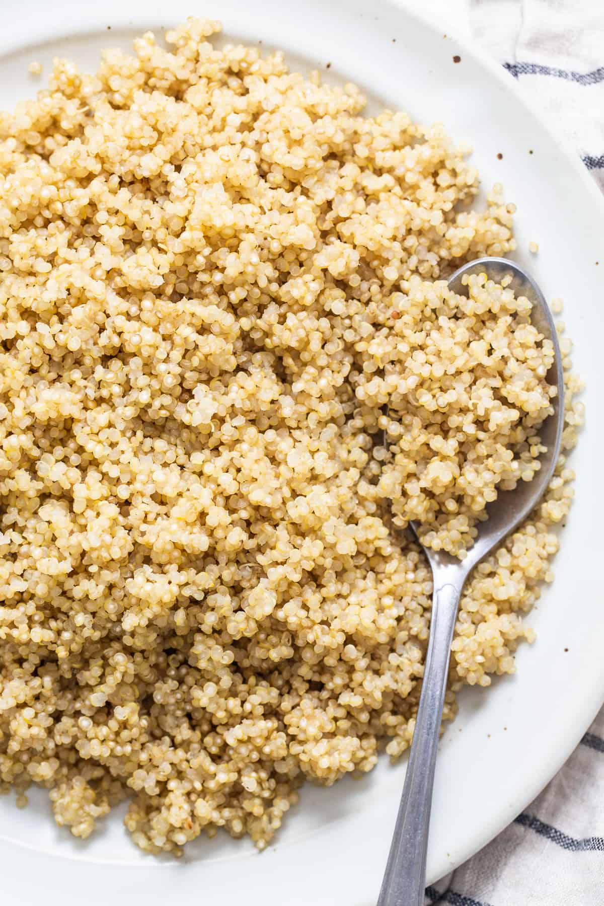 Our fool-proof Instant Pot Quinoa is perfectly fluffy every time and is faster than most other Instant Pot quinoa recipes (hello quick release!). cooked quinoa on plate.