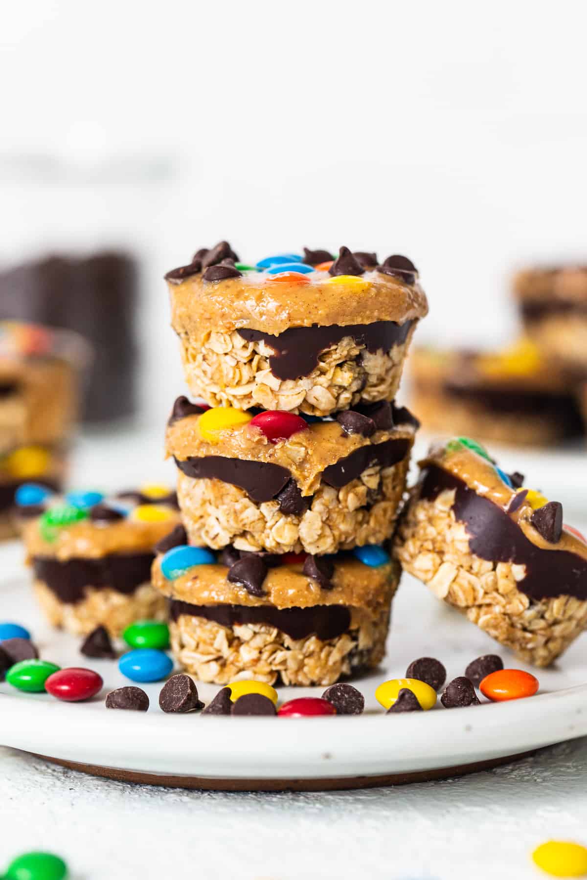 These monster cookie oat cups are an easy no-bake dessert the whole family will love! Make a large batch to keep on hand at all times -- you won't regret it. Monster cookie oat cups stacked on top of each other.