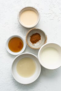 Four bowls with different ingredients on a white background.