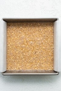 Oat bars in a baking pan on a white surface.